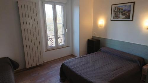 Habitación pequeña con cama y ventana en Auberge le Cévenol en La Cavalerie