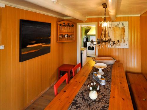 comedor con mesa de madera y paredes de color naranja en Holiday Home Lenebu - FJM231 by Interhome en Syvde
