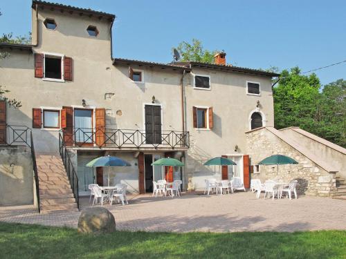 a building with chairs and umbrellas in front of it at Apartment Ca' Pignoi-5 by Interhome in Garda