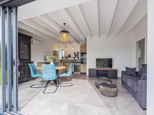 a living room with a table and blue chairs at La Marceline gîte Confort et Nature in Chef-Boutonne