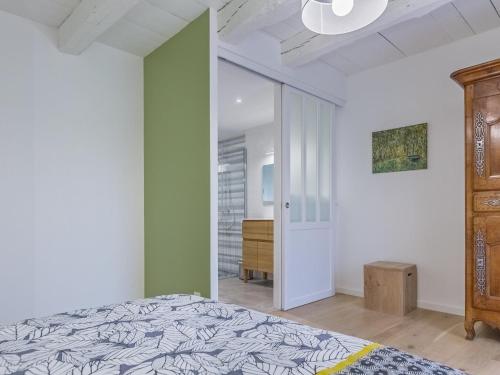 ein Schlafzimmer mit einem Bett und einer grünen Wand in der Unterkunft La Marceline gîte Confort et Nature in Chef-Boutonne