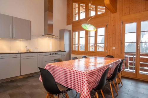 a kitchen with a table with a red and white checkered table cloth at Am Gilsbach in Adelboden