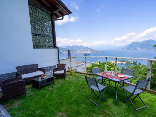 een patio met een tafel en stoelen en uitzicht op het water bij Holiday Home Tramonto - SEA116-1 by Interhome in Stresa