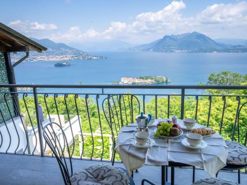 una mesa en un balcón con vistas al agua en Holiday Home Tramonto - SEA116-1 by Interhome, en Stresa