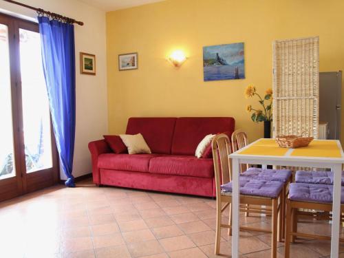 a living room with a red couch and a table at Apartment Villa Rizzardi-1 by Interhome in Malcesine