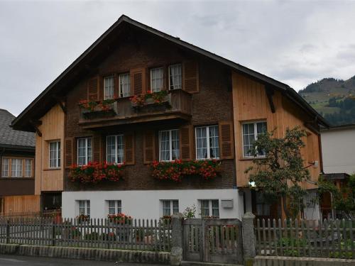 a wooden house with windows and a fence at Apartment Beatrice by Interhome in Zweisimmen