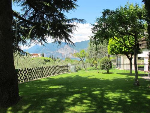 een groene tuin met een hek en een boom bij Holiday Home Rocchetta by Interhome in Malcesine