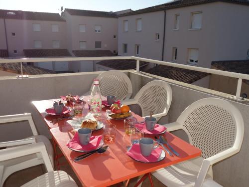 une table avec de la nourriture et des boissons sur un balcon dans l'établissement Apartment Le Myflower by Interhome, au Grau-du-Roi