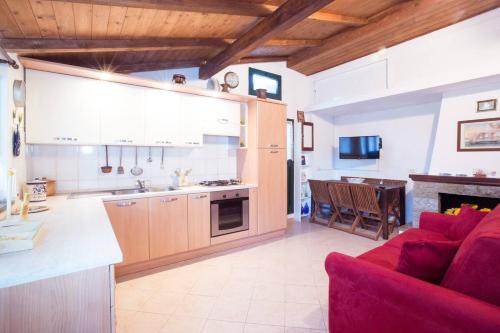 una cucina e un soggiorno con divano rosso di SUNFLOWER cosy cottage once GIRASOLE a Monterosso al Mare