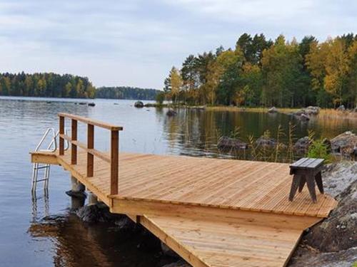 a wooden dock with a bench on a lake at Holiday Home Rihka by Interhome in Luopioinen