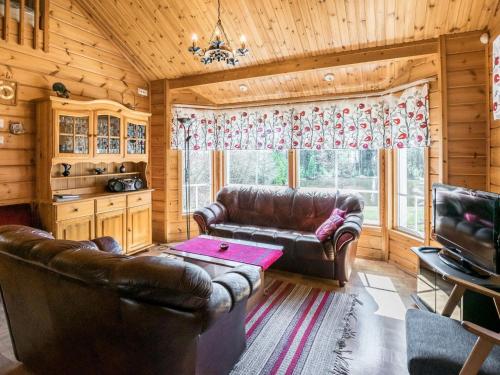 ein Wohnzimmer mit Ledersofas und einem Tisch in der Unterkunft Holiday Home Polaria by Interhome in Niittymaa