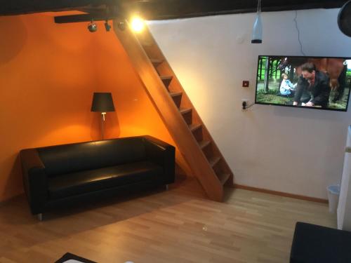 a living room with a couch and a tv on a wall at Hotel ZweiLinden Meckenheim Bonn in Meckenheim