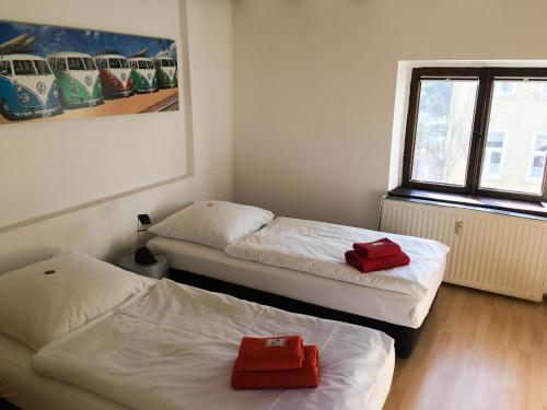 a room with two beds and a red folder at Hotel ZweiLinden Meckenheim Bonn in Meckenheim