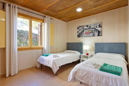 a bedroom with two beds and a window at Arenal Son Veri in El Arenal