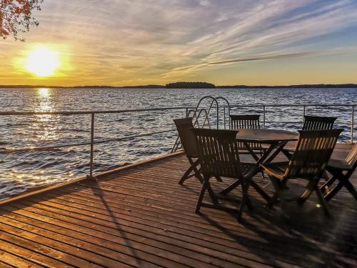 una mesa y sillas en un muelle con puesta de sol en Holiday Home Villa piranniemi by Interhome, en Onkamon Kannas
