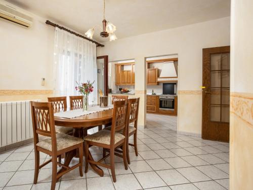 a kitchen and dining room with a wooden table and chairs at Holiday Home Legović by Interhome in Kaštelir