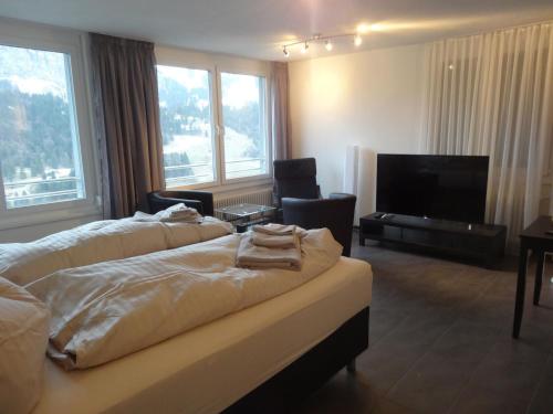 エンゲルベルクにあるApartment Barbara West by Interhomeのベッド2台、薄型テレビが備わるホテルルームです。