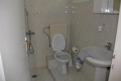 a bathroom with a toilet and a sink at Theodora Studios in Yénion