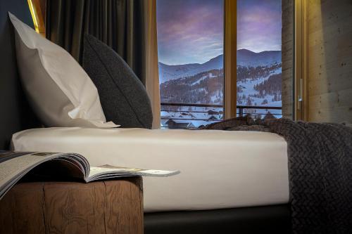 a bedroom with a bed and a window with a mountain view at Vetta Alpine Relax in Livigno