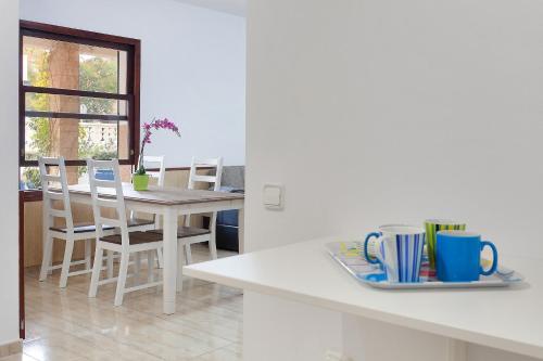 a kitchen with a table and chairs and a table with cups at Villa Can Pastilla in Can Pastilla