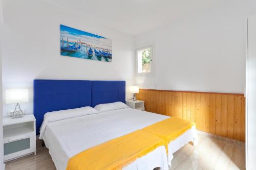 a bedroom with a bed with a blue and yellow blanket at Villa Can Pastilla in Can Pastilla