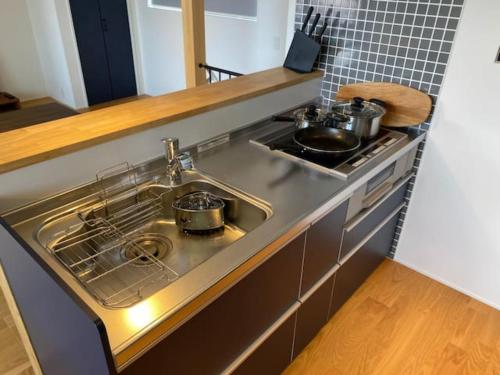 a kitchen with a sink with pots and pans at Stella House Gemini ステラハウス ジェミニ in Fujikawaguchiko