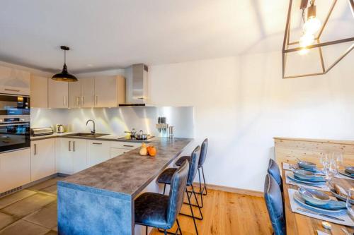 une cuisine avec un îlot bleu au milieu dans l'établissement Chalets de Vonnes 8 - Appartement - BO Immobilier - Châtel - Châtel Multipass Été 2025 en option au tarif de 3euros par jour et par personne, à Châtel
