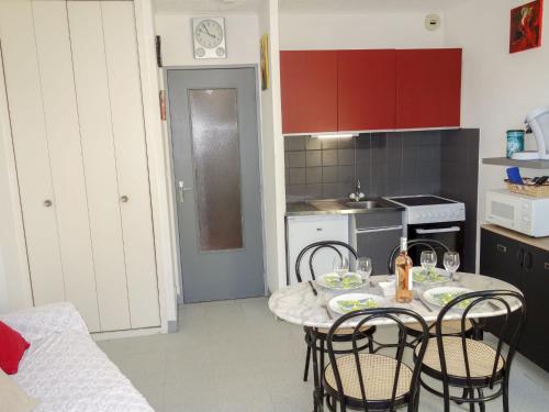 a kitchen with a table and chairs in a kitchen at Studio Le Grand Galion-3 by Interhome in Le Grau-du-Roi