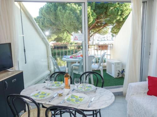 une table avec des chaises et des verres à vin sur un balcon dans l'établissement Studio Le Grand Galion-3 by Interhome, au Grau-du-Roi