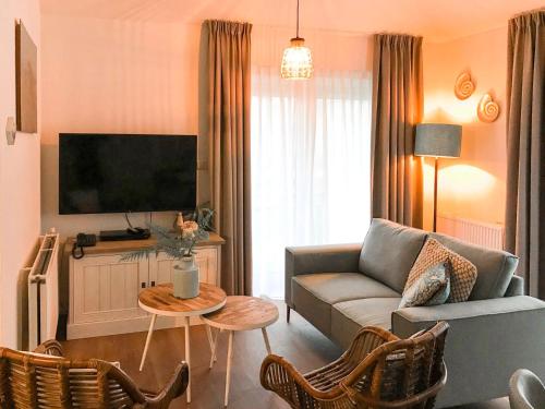 een woonkamer met een bank en een tv bij Holiday Home Citta Romana-1 by Interhome in Hellevoetsluis