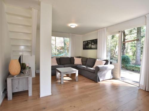a living room with a couch and a table at Chalet Oosterduinen by Interhome in Norg