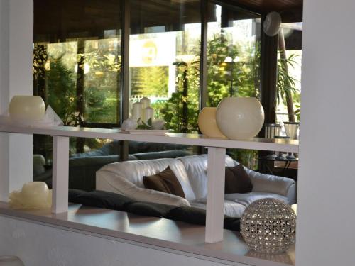 a room with a shelf with vases and a couch at Rouge Hotel International in Milano Marittima