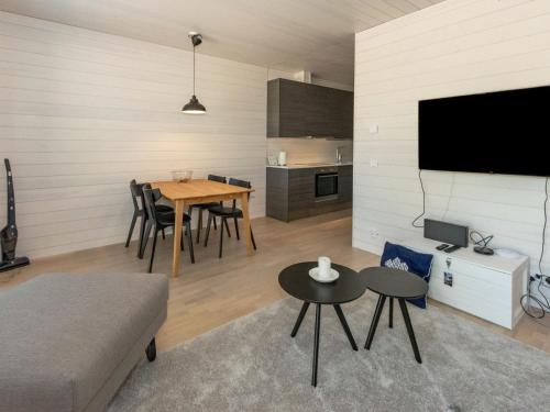 een woonkamer met een tafel en stoelen en een televisie bij Holiday Home Kasnäs marina b11 by Interhome in Kasnäs