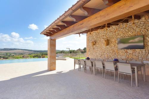 a patio with a table and chairs next to a stone wall at Sa Murtera in Manacor