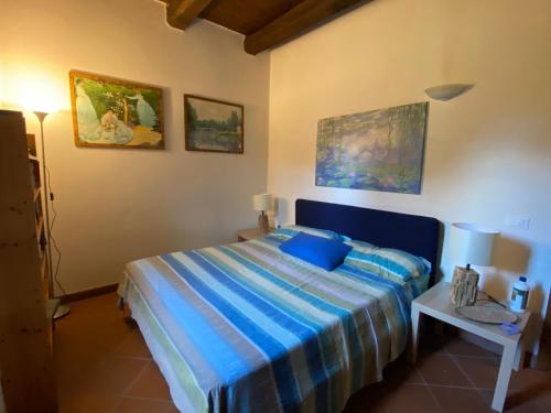 a bedroom with a bed with a blue striped bedspread at Casale ristrutturato 3 Km Tropea in Santa Domenica