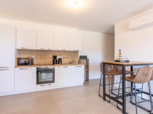 une cuisine avec des armoires blanches et une table dans l'établissement Apartment St Joseph-1 by Interhome, à Porto-Vecchio