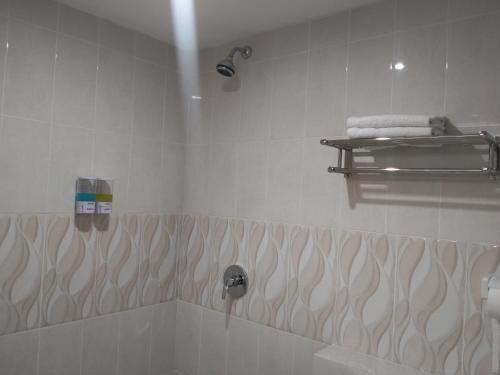 a bathroom with a tub and a shower with a towel at GRANADA INN PALU in Palu