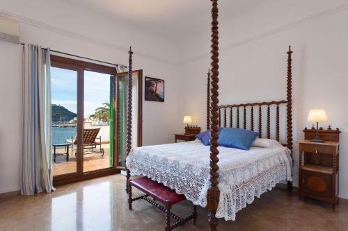 a bedroom with a four poster bed and a balcony at Sa Caleta in Port de Soller