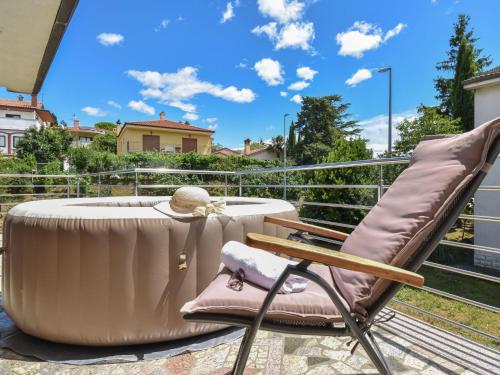 krzesło i stół na balkonie z wanną w obiekcie Apartment Aurora by Interhome w mieście Buzet