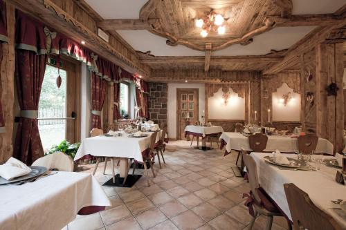 un ristorante con tavoli con tovaglie bianche di Resort Dolce Casa - Family & Spa Hotel a Moena