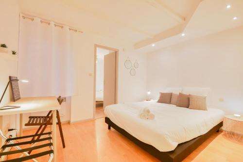 une chambre blanche avec un lit et un bureau dans l'établissement Les Cosy De Nancy - La cache du cerf - 4étoiles, à Nancy