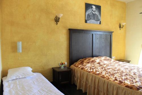 サンダンスキにあるBoutique Hotel Colosseoのベッド付きのベッドルームと男性の写真