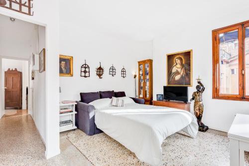 a white bedroom with a bed and a couch at Ca Lu Vintage Flat con Vista su San Marco! in Venice