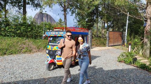 a man and woman are walking down the road with a van at Domus Glamping in Guatapé