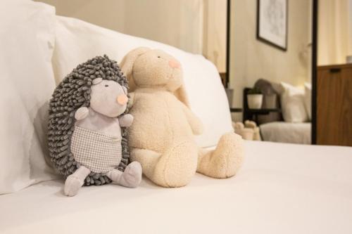 two stuffed animals sitting on top of a bed at Guest House de la Valette in Valletta