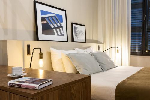 a bedroom with a bed and a table with a book on it at Guest House de la Valette in Valletta