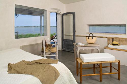 a bedroom with a bed and a table and a mirror at Lodge Sainte Helene Adult only in Saintes-Maries-de-la-Mer