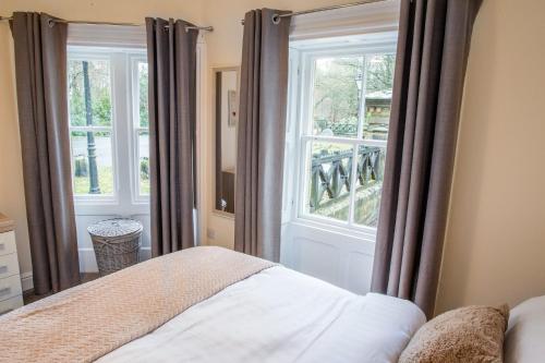a bedroom with a bed and a large window at Gate Keepers Cottage in Easington