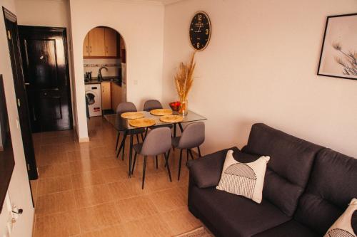 sala de estar con sofá y mesa con sillas en Aparthotel Costa Blanca, en Torrevieja
