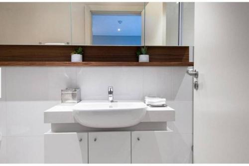 a white bathroom with a sink and a mirror at Zimbali Suite 112 in Ballito